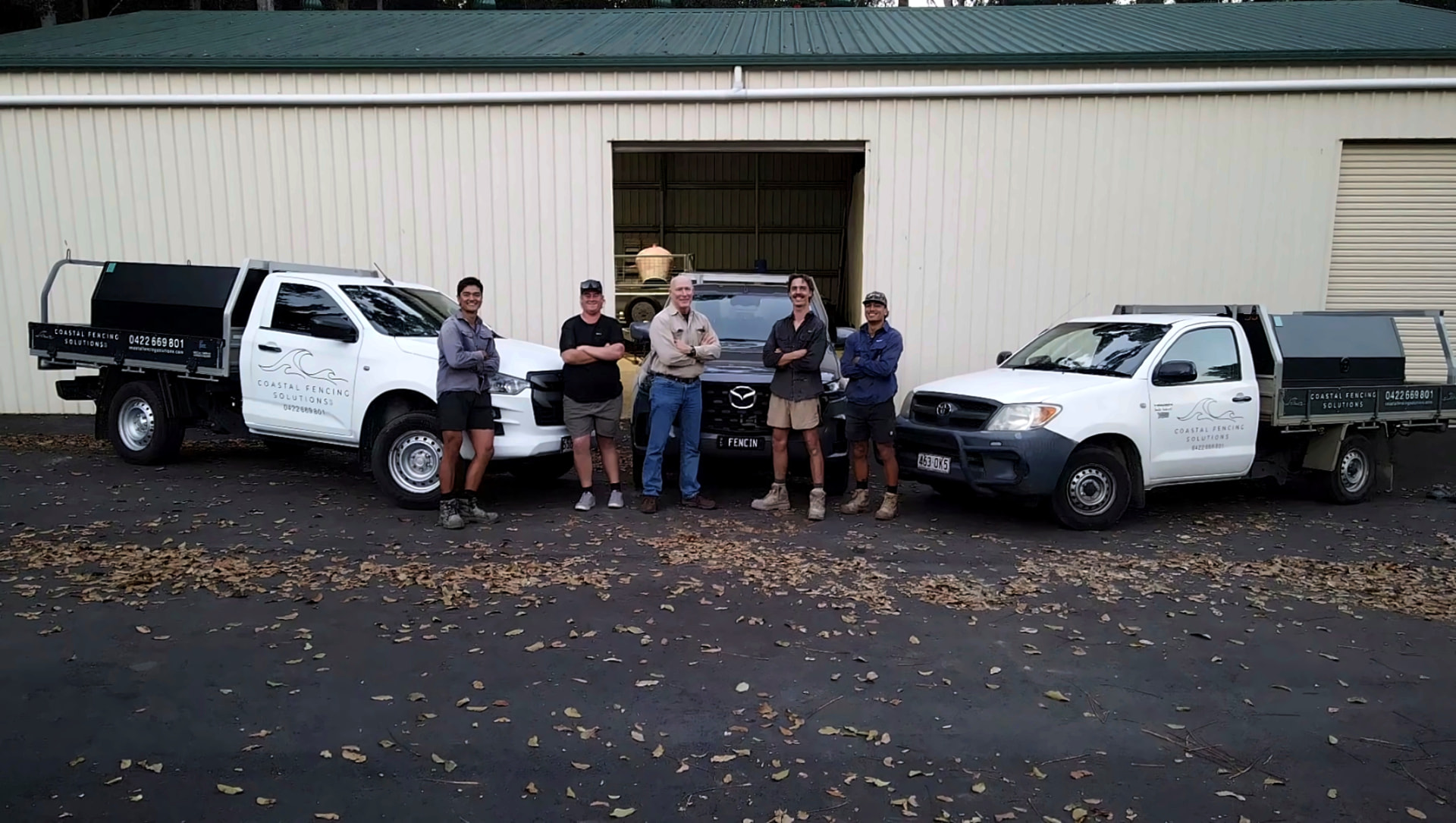 The Coastal Fencing Solutions team with their service trucks